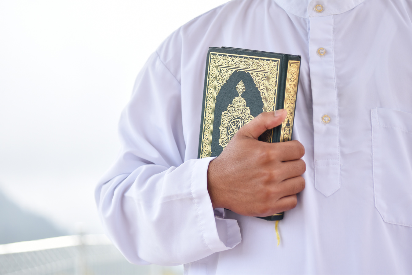 Holy Quran in Hand. Muslim man holding Quran